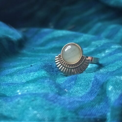 une bague avec une pierre posée sur un tissu