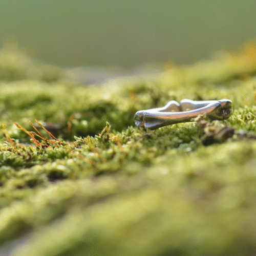 bague en argent formant trois os posée sur de la mousse.