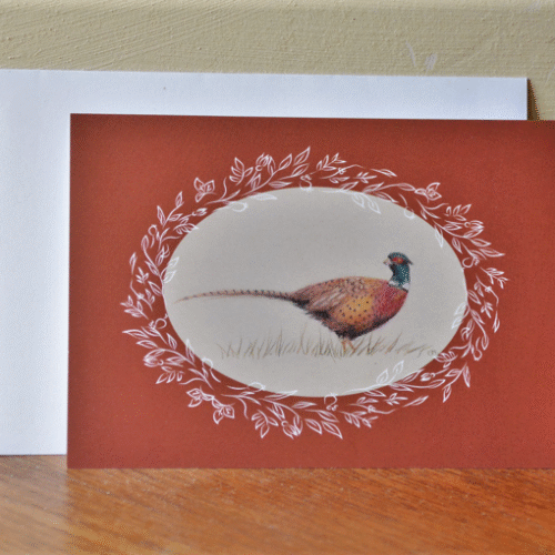 carte postale de chevreuil et enveloppe posés contre un mur.