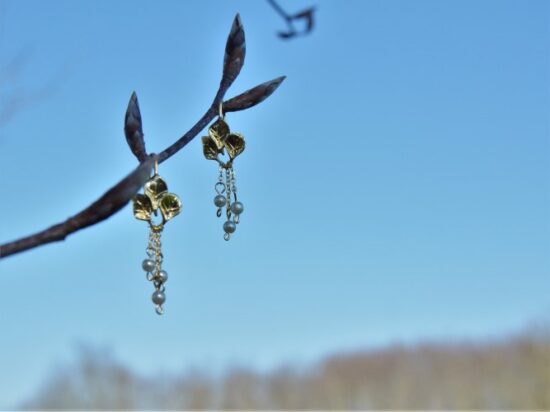 paire de boucles d'oreille avec trois feuilles et des perles pendantes.