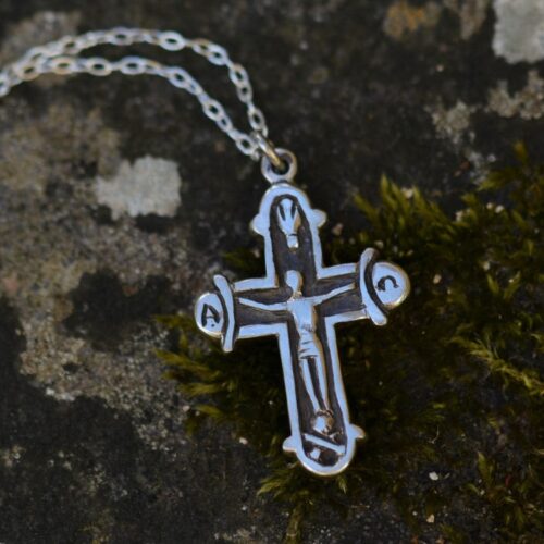 croix en argent posée sur une pierre.