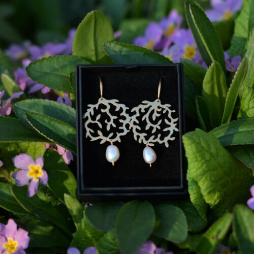 une paire de boucles d'oreilles dorées avec une perle.