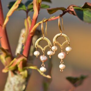 une paire de boucles d'oreilles dorées avec des perles de culture.