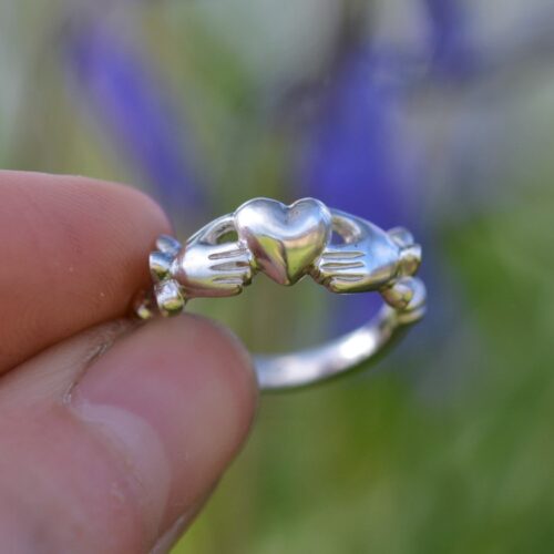 bague en argent avec deux mains tenant un coeur.