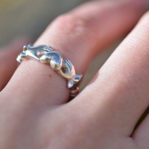bague en argent avec deux mains tenant un coeur.