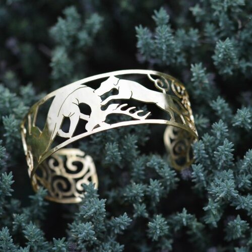 manchette en laiton plaqué or ajouré posé sur une plante