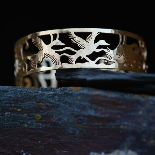 manchette en laiton plaqué or ajouré posé sur une pierre