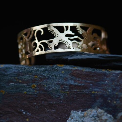 manchette en laiton plaqué or ajouré posé sur une pierre