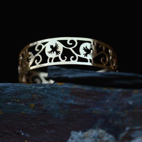 manchette en laiton plaqué or ajouré posé sur une pierre